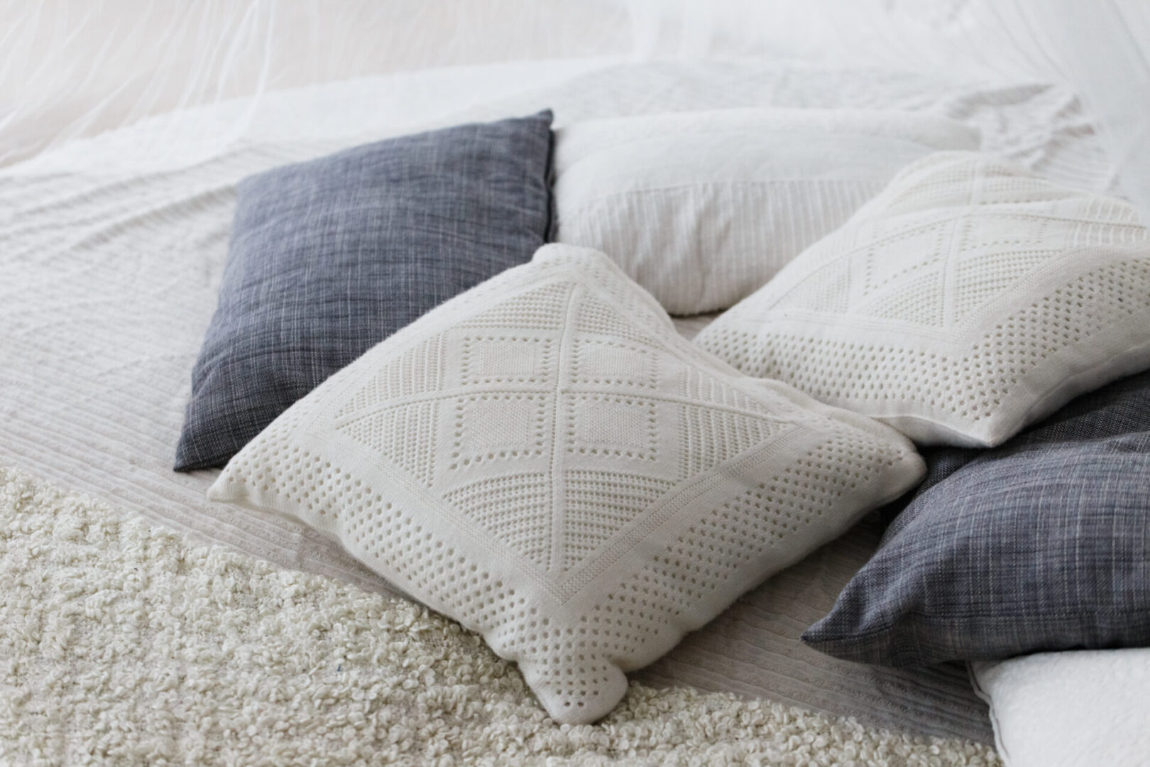 A White Color Knitted Throw Pillow on Bed