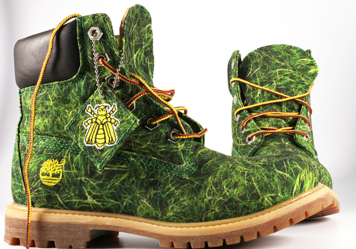 A Pair of Boots With a Grass Print and Bee Charm