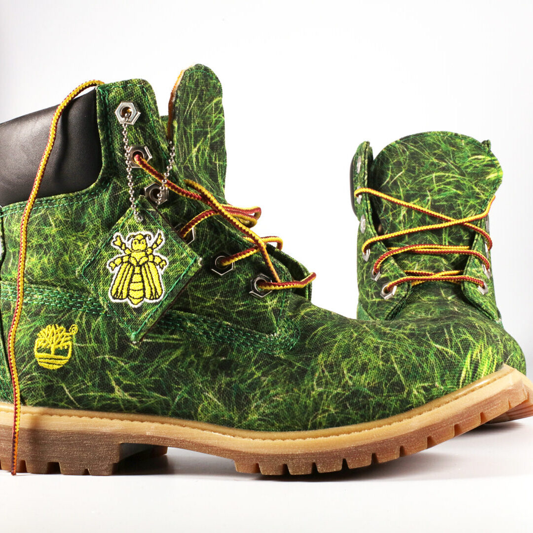 A Pair of Boots With a Grass Print and Bee Charm